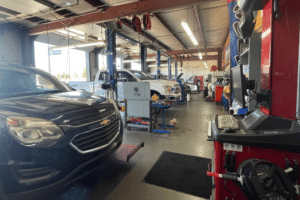 Pre-Purchase Inspection in Republic, MO at Yocum Automotive. An indoor view of a professional auto repair shop with multiple service bays and vehicles on lifts, emphasizing the comprehensive pre-purchase inspection process needed when buying a used car.